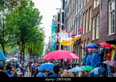 Amsterdam, Niederlande. 05. Aug. 2023. Während der Veranstaltung hängen drei Regenbogen-Einhörner aus den Fenstern heraus. Die Kanalparade beginnt gegen Mittag und dauert den ganzen Nachmittag. Rund 80 Schiffe verschiedener Organisationen und gemeinnützige Organisationen nehmen an der Veranstaltung Teil. Für die Grachtenparade ist Amsterdam Gay Pride berühmt. Es ist die Krönung ihres zweiwöchigen Festivals, das mehr als 200 Veranstaltungen umfasst. Die Boote starten am Scheepvaart-Museum im östlichen Teil des Stadtzentrums und fahren in Richtung Amstel. Kredit: SOPA Images Limited/Alamy Live News Stockfoto