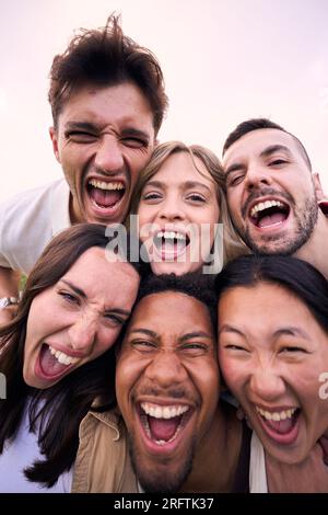Freunde aus verschiedenen Rassen im Hochformat, die sich im Freien freuen. Gruppendiversität junge Leute lustiger Ausdruck. Stockfoto