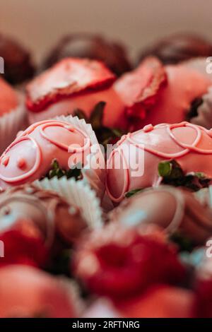 Nahaufnahme von Erdbeeren mit rosafarbener Schokolade. Süßigkeiten-Sammlung. Schmackhaftes Urlaubsset Stockfoto