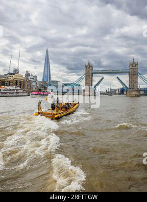 Ein Schnellboot auf der Themse fährt in Richtung der offenen Tower Bridge in Docklands, Pool of London bei Butlers Wharf, Bermondsey Stockfoto