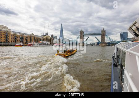 Ein Schnellboot auf der Themse fährt in Richtung der offenen Tower Bridge in Docklands, Pool of London bei Butlers Wharf, Bermondsey Stockfoto