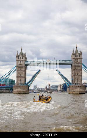Ein Schnellboot auf der Themse fährt in Richtung der offenen Tower Bridge in Docklands, Pool of London bei Butlers Wharf, Bermondsey Stockfoto
