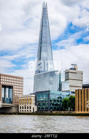 Der berühmte moderne Shard Wolkenkratzer in Southwark SE1 und die London Bridge, die von der Themse in London aus vor einem wolkigen Himmel zu sehen sind Stockfoto