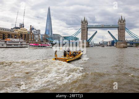 Ein Schnellboot auf der Themse fährt in Richtung der offenen Tower Bridge in Docklands, Pool of London bei Butlers Wharf, Bermondsey Stockfoto