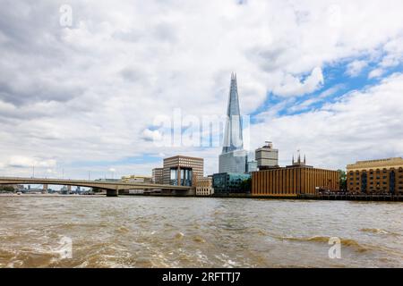 Der berühmte moderne Shard Wolkenkratzer in Southwark SE1 und die London Bridge, die von der Themse in London aus vor einem wolkigen Himmel zu sehen sind Stockfoto