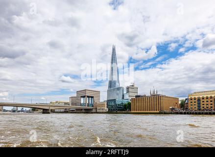 Der berühmte moderne Shard Wolkenkratzer in Southwark SE1 und die London Bridge, die von der Themse in London aus vor einem wolkigen Himmel zu sehen sind Stockfoto