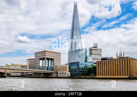 Der berühmte moderne Shard Wolkenkratzer in Southwark SE1 und die London Bridge, die von der Themse in London aus vor einem wolkigen Himmel zu sehen sind Stockfoto