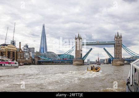 Ein Schnellboot auf der Themse fährt in Richtung der offenen Tower Bridge in Docklands, Pool of London bei Butlers Wharf, Bermondsey Stockfoto