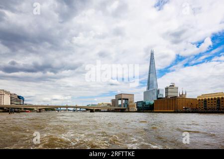 Der berühmte moderne Shard Wolkenkratzer in Southwark SE1 und die London Bridge, die von der Themse in London aus vor einem wolkigen Himmel zu sehen sind Stockfoto