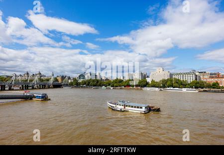 Blick auf die Charing Cross Station entlang Victoria Embankment zum Shell Mex House und festgemachte Themse Flussufer auf der Themse am Woods Quay London WC2 Stockfoto