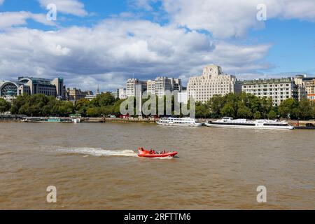 Ein RIB der Themse RIB fährt am Shell Mex House am Victoria Embankment vorbei und verlegte die Themse am Flussufer am Woods Quay, London WC2 Stockfoto