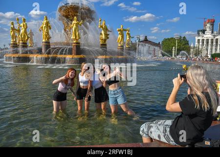 Moskau, Russland. 5. Aug. 2023. Mädchen posieren für ein Foto, während sie sich am 5. August 2023 in Moskau, Russland, im Brunnen der Freunde der Völker auf der VDNH (Ausstellung der Leistungen der nationalen Wirtschaft) abkühlen. Kredit: Alexander Zemlianichenko Jr/Xinhua/Alamy Live News Stockfoto