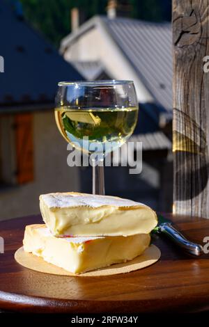 Französischer Reblochon-Käse aus Haute-Savoie, Weißwein Roussette de Savoie oder Vin de Savoie mit Blick auf das alte Alripne-Dorf und den Berg Hautes Alpes Stockfoto