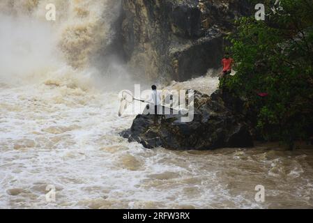 Indien, Jabalpur, Madhya Pradesh, 06. August 2023: Ein Fischer nutzt ein Netz, um in rauen Gewässern neben den Dhuandhar-Fällen nach starken Regenfällen auf dem Narmada-Fluss in Bhedhaghat in Jabalpur, Madhya Pradesh, Fische zu fangen. Foto Von - Uma Shankar Mishra/Alamy Live News Stockfoto