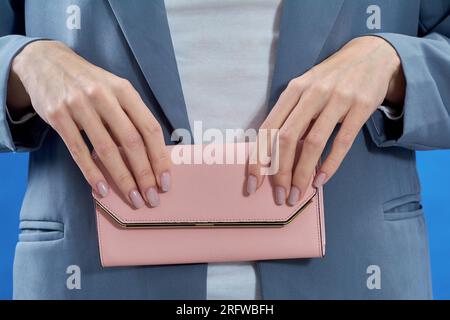 Frauenhände halten eine rosa Handtasche Stockfoto