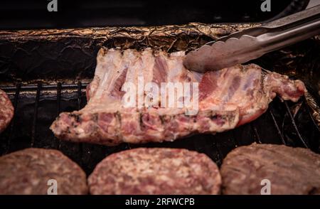 Umdrehen der Rippen auf der BBQ-Grill Stockfoto