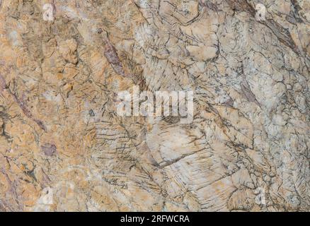 Die Oberfläche des gelben Steins weist Spuren von Alter und Alter auf. Stockfoto