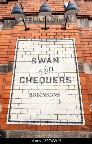 Swan and Chequers Pub-Schild an der Außenwand von Großbritannien Stockfoto