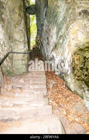 Wanderweg mit einer Treppe zwischen zwei Felsformationen im Naturschutzgebiet Teufelsschlucht, festsitzender Felsen im Hintergrund, sonniges summ Stockfoto