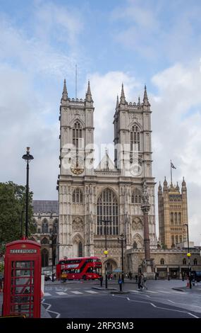 Vor der Westminster Abbey mit rotem Bus und roter Telefonzelle Stockfoto