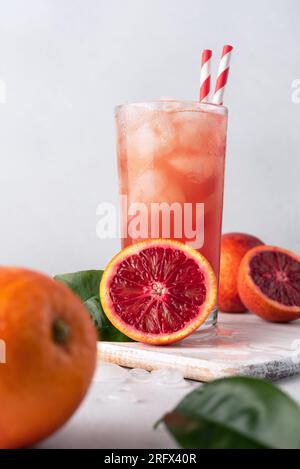 Erfrischungsgetränk. Roter oder Blut sizilianischer Orangensaft in einem Glas und frische Orangen. Stockfoto