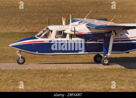 14. April 2023, Niedersachsen, Wangerooge: 14.04.2023, Wangerooge. Ein Pilot der FLN Frisia-Luftverkehr GmbH mit seinem Britten-Norman BN-2 Islander Flugzeug auf dem Flughafen der ostfriesischen Insel Wangerooge. Die Flugzeuge des Unternehmens müssen besonders robust, stabil und unempfindlich gegenüber starken Winden für den Inselluftverkehr und den Betrieb über der Nordsee sein. Das Flugzeug benötigt auch nur sehr kurze Pisten für Start und Landung. Foto: Wolfram Steinberg/dpa Foto: Wolfram Steinberg/dpa Stockfoto