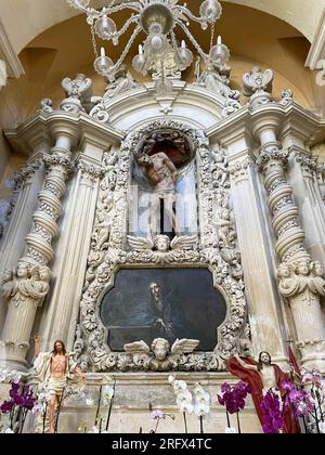 Lecce, Italien. Das Innere der Kirche St. Maria vom Karmel. Altar, der der schmerzlichen Mutter gewidmet ist, mit einer Skulptur Christi an der Säule. Stockfoto