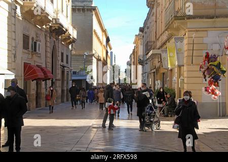 Lecce, Italien. Menschen, die während der COVID-19-Pandemie auf der Via Salvatore Trinchese im historischen Zentrum wandern und Masken tragen. Stockfoto