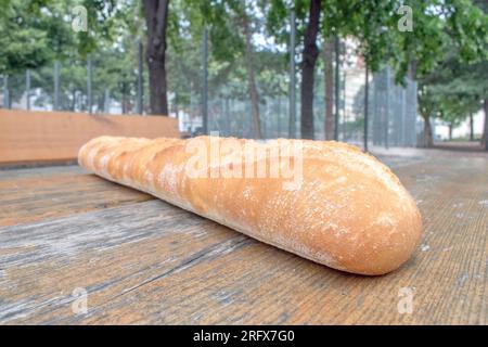 Crispy Baguette: Ein wunderbares Foto mit einem langen, knusprigen Baguette auf einem Tisch. Perfekt für Freizeit- und Outdoor-Dini Stockfoto