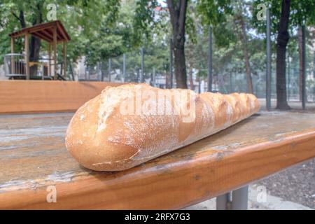 Crispy Baguette: Ein wunderbares Foto mit einem langen, knusprigen Baguette auf einem Tisch. Perfekt für Freizeit- und Outdoor-Dini Stockfoto