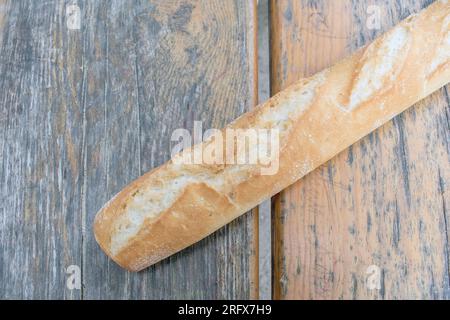 Crispy Baguette: Ein wunderbares Foto mit einem langen, knusprigen Baguette auf einem Tisch. Perfekt für Freizeit- und Outdoor-Dini Stockfoto