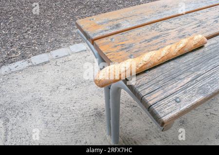 Crispy Baguette: Ein wunderbares Foto mit einem langen, knusprigen Baguette auf einem Tisch. Perfekt für Freizeit- und Outdoor-Dini Stockfoto