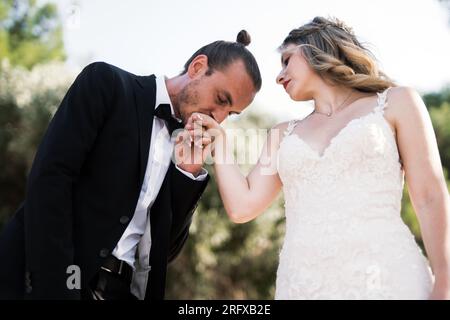 Ein charmanter Bräutigam Küsst die Hand der Braut Stockfoto