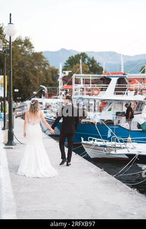 Ein Brautpaar das einen Spaziergang am traditionellen Hafen von Thasso macht. Stockfoto