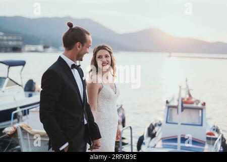 Ein Brautpaar das einen Spaziergang am traditionellen Hafen von Thasso macht. Stockfoto