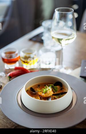 Garnelen-Bisque mit Meeresfrüchten. Riesengarnelen, blaue Muscheln, Kabeljau, Schlagsahne. Köstliches traditionelles Essen in der Nähe serviert zum Mittagessen in modernem Gourmet Stockfoto