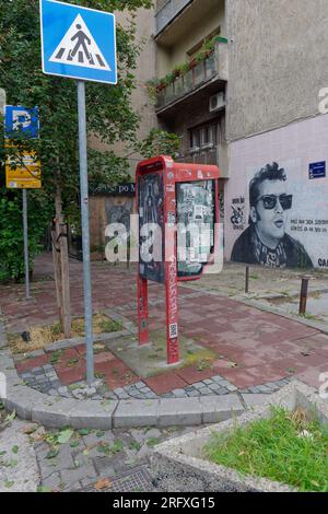 Telefonzelle und Street Art in einem grauen, düsteren und deprimierenden Wohnhaus in der Hauptstadt Belgrad, Serbien. August 2023. Stockfoto