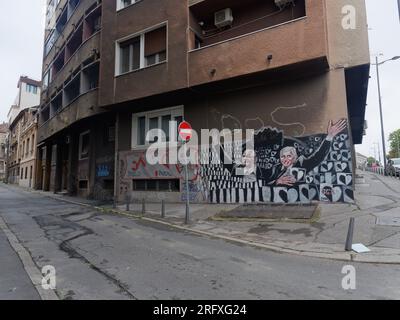 Street Art / Graffiti auf einem braunen, düsteren und deprimierenden Wohnhaus in der Hauptstadt Belgrad, Serbien. August 2023. Stockfoto