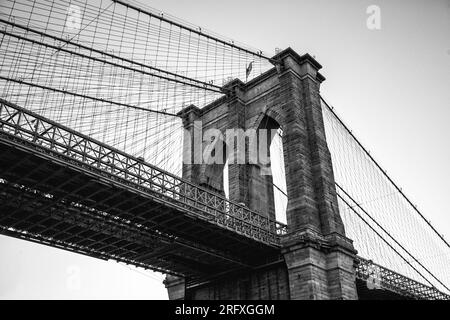 Erleben Sie den majestätischen Reiz der Brooklyn Bridge, ein architektonisches Wunderwerk am East River in New York City. Erleben Sie die Schönheit urbaner Engi Stockfoto