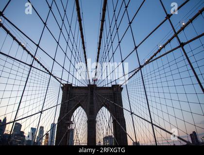 Erleben Sie den majestätischen Reiz der Brooklyn Bridge, ein architektonisches Wunderwerk am East River in New York City. Erleben Sie die Schönheit urbaner Engi Stockfoto