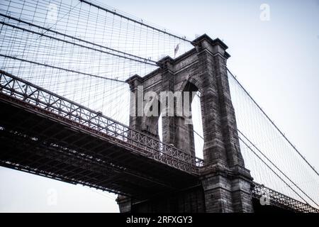 Erleben Sie den majestätischen Reiz der Brooklyn Bridge, ein architektonisches Wunderwerk am East River in New York City. Erleben Sie die Schönheit urbaner Engi Stockfoto