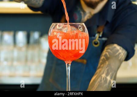Barkeeper schüttet Alkohol in einen Cocktail Stockfoto