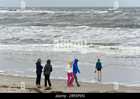 Spaziergänger am Nordseestrand an einem kühlen Sommertag, Langeoog, Ostfriesische Inseln, Niedersachsen, Deutschland Stockfoto