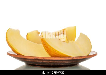 Drei Scheiben gelbe Melone auf einer Tonplatte, Makro, isoliert auf weißem Hintergrund. Stockfoto