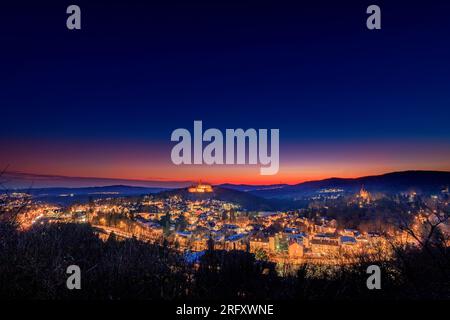 Königstein im Taunus bei Frankfurt. Blick auf die Burgruinen nach dem Sonnenuntergang. Beleuchtetes Schloss und Dorf im Winter Stockfoto