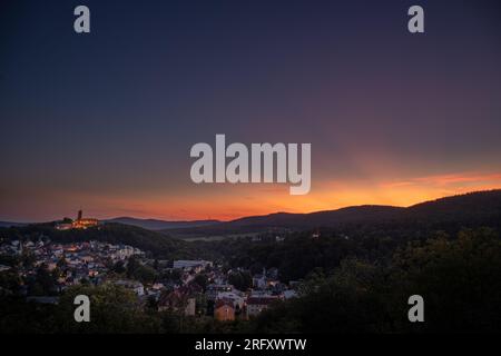 Königstein im Taunus bei Frankfurt. Blick auf die Burgruinen nach dem Sonnenuntergang. Beleuchtetes Schloss und Dorf im Winter Stockfoto