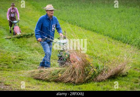 Braunsbach Steinkirchen, Deutschland. 06. Aug. 2023. Die Teilnehmer der Mountain Mower World Cup laufen mit ihren Bergmähern über einen Teil des Wettbewerbskurses. Kredit: Christoph Schmidt/dpa/Alamy Live News Stockfoto