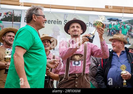 Braunsbach Steinkirchen, Deutschland. 06. Aug. 2023. Michael Sack aus Eberbach am Neckar steht als Gewinner der Weltmeisterschaft in Braunsbach-Steinkirchen auf der Bühne und hebt die Trophäe des Gewinners in die Luft. Kredit: Christoph Schmidt/dpa/Alamy Live News Stockfoto