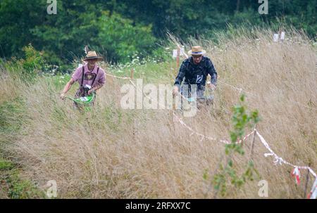 Braunsbach Steinkirchen, Deutschland. 06. Aug. 2023. Teilnehmer der Mountain Mower World Cup fahren mit ihren Bergmähern einen Teil des Rennplatzes und mähen dabei hohes Gras. Kredit: Christoph Schmidt/dpa/Alamy Live News Stockfoto