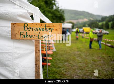 Braunsbach Steinkirchen, Deutschland. 06. Aug. 2023. Das Fahrerlager für den Bergmäher ist während der Mountain Mower World Cup auf einem Holzschild vor einem Zelt geschrieben. Kredit: Christoph Schmidt/dpa/Alamy Live News Stockfoto